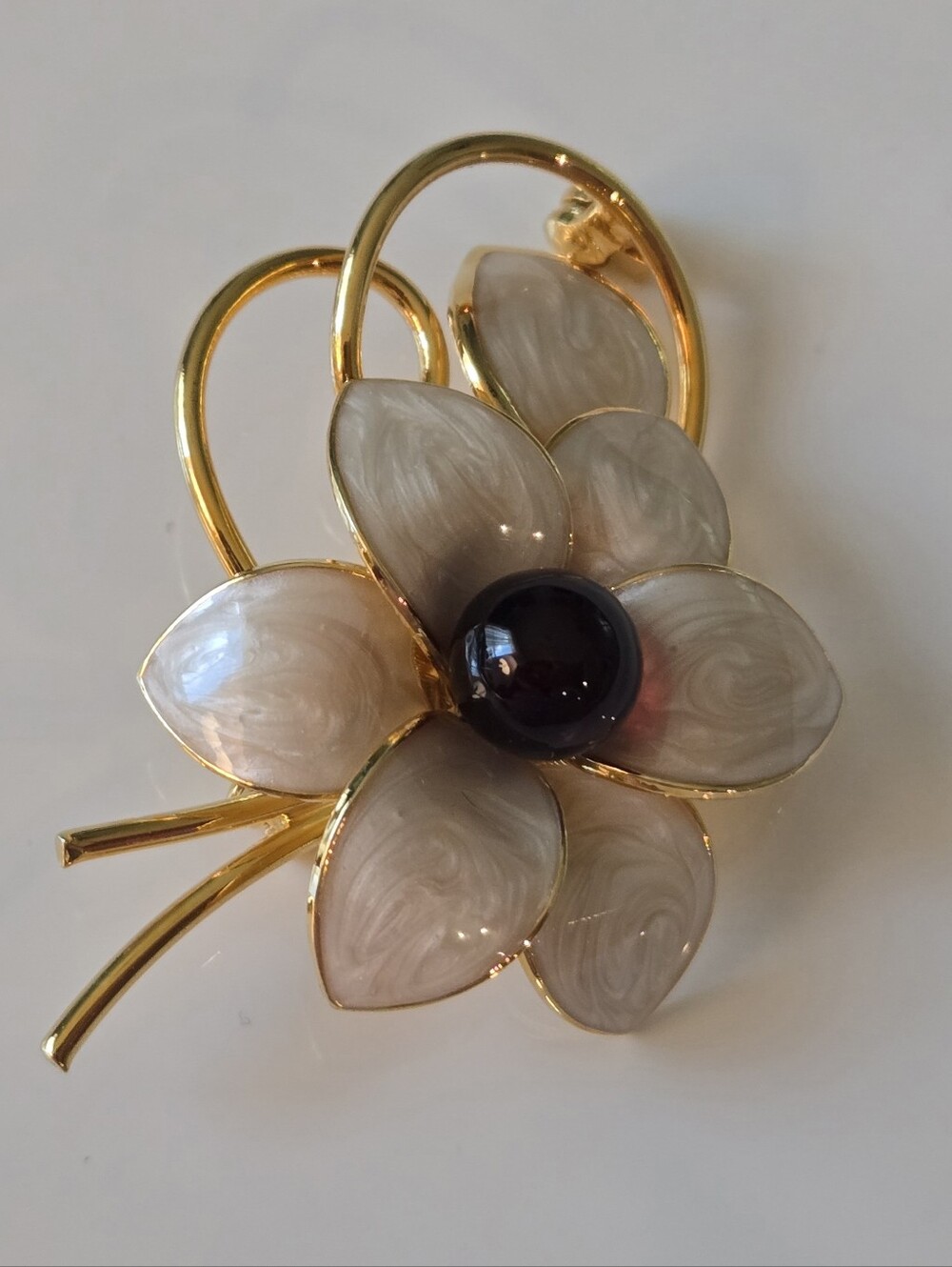 Gold-Tone Floral Brooch with Cream Enamel Petals and Black Center.
